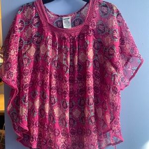 A pink purple and teal blouse with a pink layer underneath